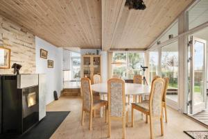 a dining room with a table and chairs and a fireplace at R623-Rodvig-Laurasvej-13 in Rødvig