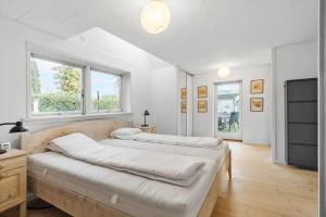 a large white bedroom with two beds and windows at R623-Rodvig-Laurasvej-13 in Rødvig