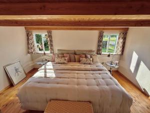 a large bed in a room with two windows at 6040-Stege-Rytsebaekvej-39 in Stege
