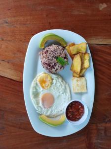 a plate of breakfast food with an egg and toast at Sunny Garden Lodge in Mérida