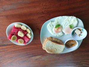 two plates of food with eggs and bread on a table at Sunny Garden Lodge in Mérida +11 photos