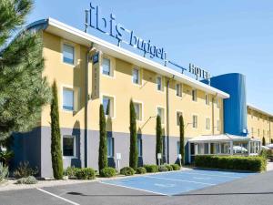 a hotel with a tennis court in front of it at ibis budget Issoire in Issoire