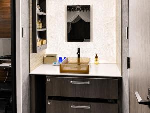 a bathroom with a sink and a mirror at Hotel BaliBali 仙台 in Kōtōdaitōri
