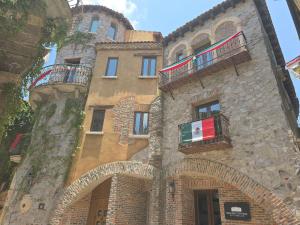 a large stone building with a flag on it at Castello di Carlo – Carlo VI Loft in Santeagueda