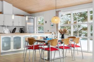 a kitchen with red chairs and a table with a counter at HA364-Hals-Hou-Mose-19 in Hals