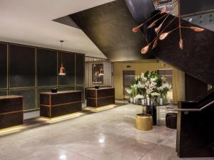 a lobby with a salon with flowers and a staircase at Sofitel Wellington in Wellington
