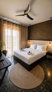 a bedroom with a large bed with a ceiling fan at Well Being Luxury Apartments in Evdilos