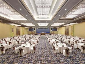 a large banquet hall with white tables and chairs at Grand Mercure Medan Angkasa in Medan +85 photos
