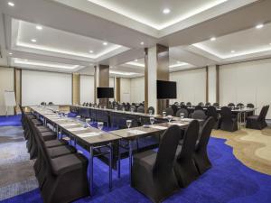 a conference room with a long table and chairs at Ibis Styles Jakarta Sunter in Jakarta +46 photos
