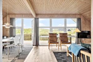 a living room with a table and chairs and a large window at 380-Harboore-Bethaniavej-9 in Harboør