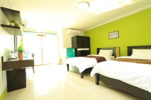 2 camas en una habitación con paredes verdes en See View Place, en Chiang Rai