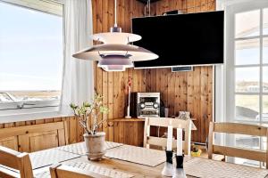 a dining room with a table and a flat screen tv at 4468-Hvide-Sande-Tingodden-427 in Hvide Sande