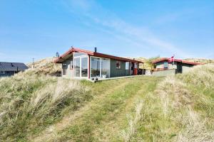 a house on top of a grass covered field at 4468-Hvide-Sande-Tingodden-427 in Hvide Sande