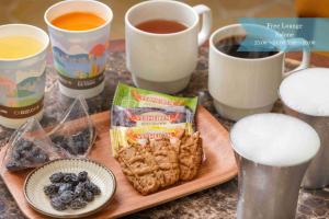 a table with cups of coffee and a plate of cookies at La Vista Atami Terrace in Atami