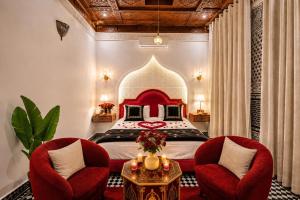 a bedroom with a red bed and two chairs at Riad Fes Palais Bab Sahra Suites & Cooking Workshops in Fez +91 photos