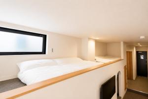 a bedroom with two beds and a flat screen tv at Tsunagu森ノ宮 in Osaka +23 photos