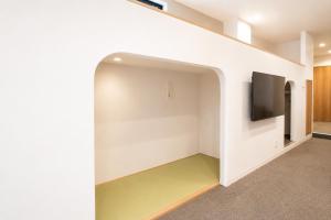 an empty room with a tv and a wall at Tsunagu森ノ宮 in Osaka