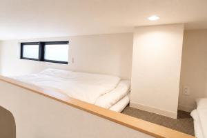 a bed in a room with a window at Tsunagu森ノ宮 in Osaka