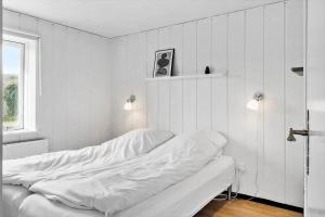 a white bedroom with a bed and a window at 724-Thyboron-Kirkevej-9 in Thyborøn