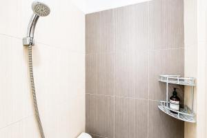 a shower with a shower head in a bathroom at RedDoorz @ Galuh Mas in Karawang