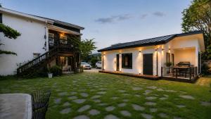 a house with a yard in front of a building at Pocheon Skygaram Pension in Pocheon