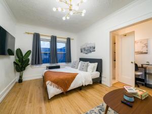a bedroom with a bed and a table at High Falls Studio TV Kitchen Downtown Rochester in Rochester +12 photos