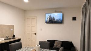 a living room with a couch and a tv on the wall at Departamentos Turísticos Cloe 2 in Fiambalá