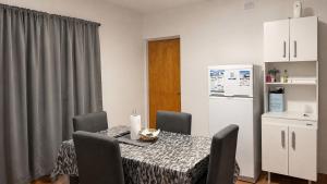 a dining room table with chairs and a white refrigerator at Departamentos Turísticos Cloe 2 in Fiambalá +11 photos