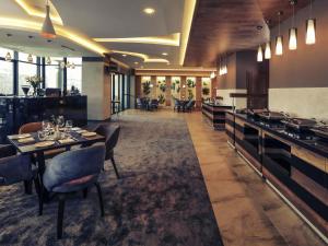 a restaurant with tables and chairs and a bar at Mercure Tetovo in Tetovo