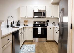 a kitchen with white cabinets and a stainless steel refrigerator at Wlk 2 MSU Fire Pit Pickleball Sleeps 8 in Starkville