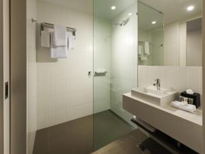a bathroom with a sink and a glass shower at ibis Brisbane Airport in Brisbane +27 photos
