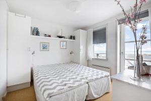 a white bedroom with a bed and a window at 4170-Borre-Klintholm-Havneby-70 in Borre
