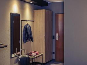 a room with a closet and a table with a jacket at Mercure Stuttgart Zuffenhausen in Stuttgart