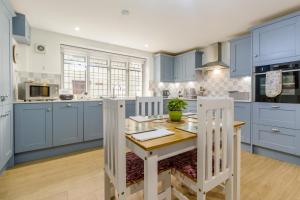 a kitchen with blue cabinets and a wooden table at 2 Bed in Ludlow oc-78885 in Ludlow