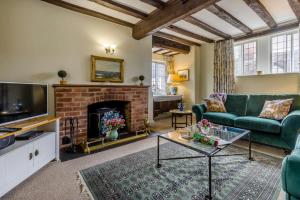 a living room with a green couch and a fireplace at 2 Bed in Ludlow oc-78885 in Ludlow