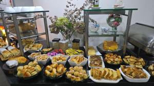 a table topped with lots of different types of food at Via Contorno Hotel in Belo Horizonte