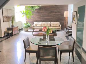 a living room with a table and chairs and a couch at Via Contorno Hotel in Belo Horizonte