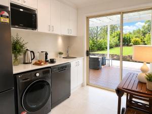a kitchen with a dishwasher and a kitchen with a patio at Palacete Beach - Resort Style Stay in Culburra Beach