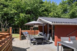 a patio with a table and chairs and an umbrella at 0651-Toftlund-Skikkild-bjerge-20 in Toftlund