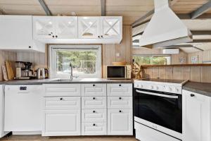 a kitchen with white cabinets and a sink at 0048-Romo-Trinnesvej-12 in Høm