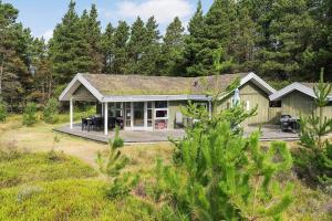 a house with a deck in the woods at 0048-Romo-Trinnesvej-12 in Høm