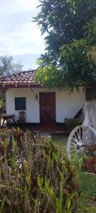a small white house with a tree and a wheel at Hotel Playa Santa Martha in Rivas