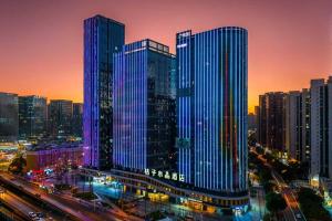 a group of tall buildings in a city at night at Orange Crystal Hotel Kunming Wanda Plaza in Kunming