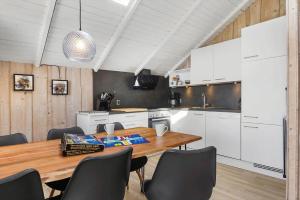 a kitchen with a wooden table and white cabinets at 0294-Romo-Vestergade-3-Ap-57 in Høm +20 photos