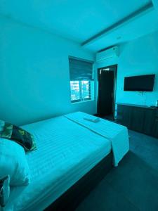 a bedroom with a large bed with blue lighting at Hoàng Long Hotel 