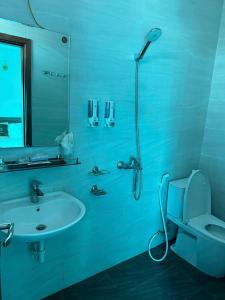 a blue bathroom with a toilet and a sink at Hoàng Long Hotel 