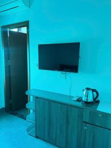 a blue room with a television on a blue wall at Hoàng Long Hotel 