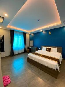 a bedroom with a large bed with a blue wall at Hoàng Long Hotel 