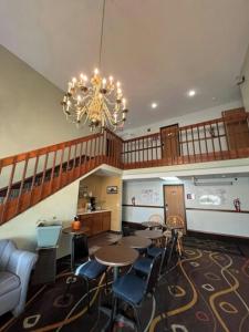 a room with tables and chairs and a chandelier at Deluxe Inn Hotel in Nebraska City in Nebraska City