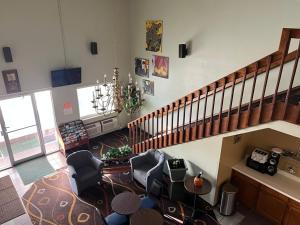 a large living room with chairs and a staircase at Deluxe Inn Hotel in Nebraska City in Nebraska City